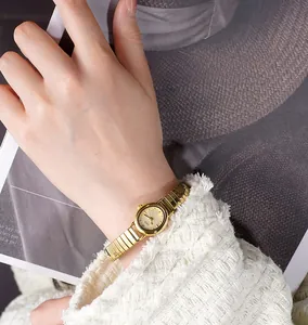 Close-up of elegant gold vintage women's watch with quartz dial and elastic bracelet