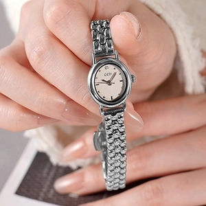 Orologio ovale da donna in argento con cinturino a perline vintage su sfondo in maglia