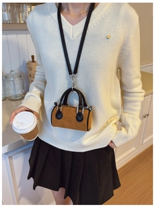 Détail du mini sac seau en velours côtelé jaune gingembre avec lanière en cuir noir