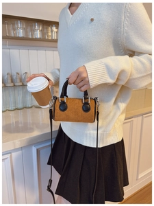 Détail du sac seau vintage en velours côtelé marron avec lanières en cuir et boucles