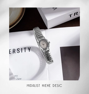 Close-up of GEDI women's silver watch with elastic band on a white book surface