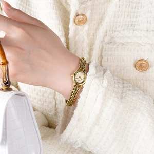 Montre élégante en acier inoxydable doré avec bracelet chaîne au poignet d'une femme