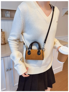 Détail d'un mini sac seau rétro en velours côtelé avec finitions en cuir noir et boucles argent