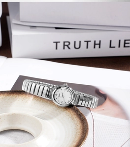 Detail showing elegant silver quartz watch with metallic stretch band and oval dial