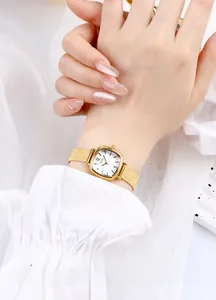 Wrist shot of a gold square quartz watch for women with a fine frosted metal strap