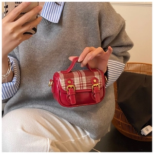 Close-up of girls vintage plaid wool shoulder bag with red faux leather and gold buckles