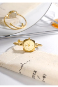 Vista dettagliata dell'orologio a bracciale intrecciato dorato con quadrante rettangolare