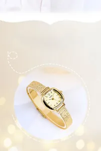 Macro shot of elegant gold-tone quartz watch with square dial and mesh strap detail