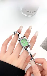 Makroaufnahme der silbernen rechteckigen Uhr mit grünem Zifferblatt und feiner Metallkette