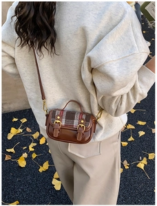 Outdoor view of a vintage plaid wool shoulder bag for girls with golden buckles