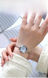 Dettaglio di un orologio quadrato in argento con quadrante blu e cinturino a cavo