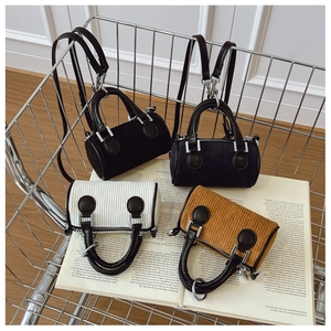 Détail de quatre mini sacs barils en velours côtelé dans un chariot métallique