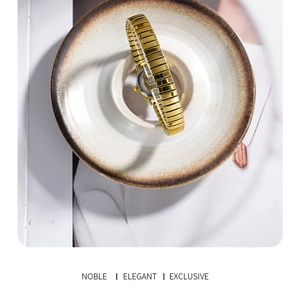 Detailed shot of golden stretch metal watch strap with fine texture in a ceramic bowl