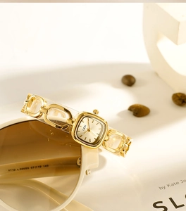 Detail of luxury gold square quartz watch with unique chain strap and minimalist dial