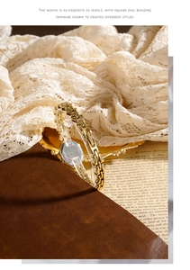 Detail of elegant gold octagonal quartz watch with luxury chain bracelet on lace fabric