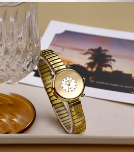 Detailed close-up of a GEDI gold-tone women's quartz watch with a stretch metal strap