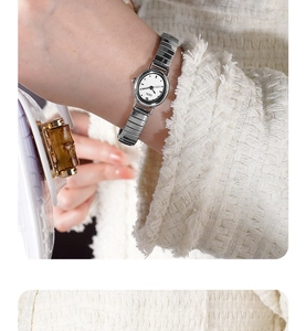 Close-up of GEDI mini silver metal watch with white dial on a woman's wrist