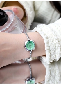 Dettaglio macro dell'orologio a bracciale a treccia argento con quadrante menta