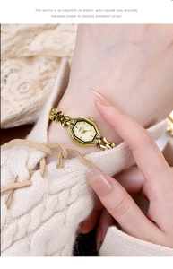 Macro detail of elegant octagonal gold chain watch worn on a knit sleeve