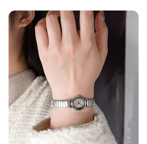 Detailed close-up of a silver elastic stretch band watch for women on a wrist