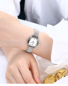 Elegant silver mesh strap quartz watch for women worn on wrist with square dial detail