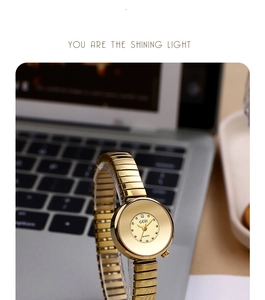 Detail view of gold sunray dial quartz watch with unique elastic stretch metal band