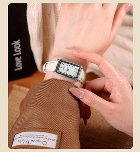 Classic rectangle silver watch with white leather strap shown on a woman wrist