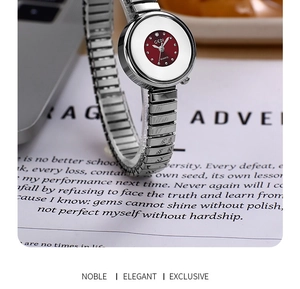 Detail of silver expansion band watch with burgundy dial on a magazine background