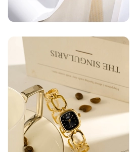 Close-up of golden vintage square quartz watch with black dial on a beige background