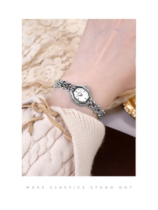 Detail of silver octagonal bracelet watch on wrist with elegant lace and knit sleeve