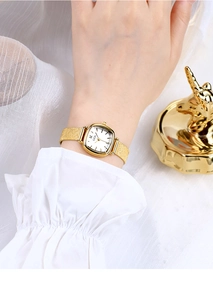 Close-up of GEDI gold square watch on wrist with a textured fine metal mesh strap