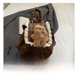 Dettaglio zaino per bambini a quadretti con pizzo e decorazione orsetto di peluche
