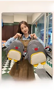 Vue détaillée d'un sac à dos pingouin gris avec un mini porte-clés pingouin assorti