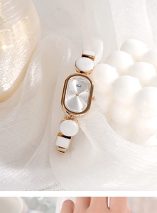 Detail of elegant oval rose gold watch with white jewelry-style ceramic link bracelet
