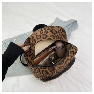 Détails du rangement interne du sac à dos léopard contenant portefeuille et téléphone