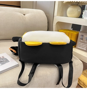 Vue détaillée du sac à dos peluche pingouin avec fourrure noir et blanc et décors jaunes