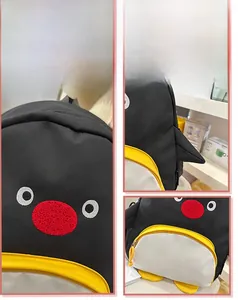 Détails du sac à dos pingouin montrant les broderies du visage et les ailes en relief 3D