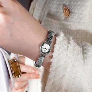 Elegant oval silver ladies quartz watch with polished metallic chain strap on wrist