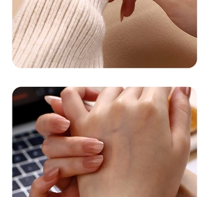 Close-up of nude pink almond-shaped press-on nails with white knit sweater sleeve details
