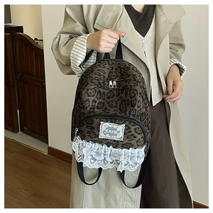 Détail du sac à dos léopard avec bordure en dentelle blanche et sangles noires