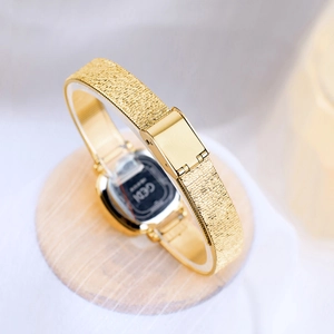 Elegant gold quartz watch for women featuring a minimalist square dial and mesh strap