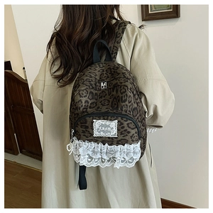 Détail du sac à dos enfant à motif léopard avec dentelle et pendentif cœur perlé