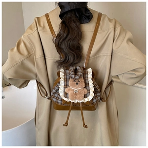 Dettaglio dello zaino bimbi vintage a quadretti con pizzo e orsetto di peluche