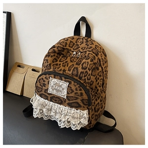 Détail du sac à dos léopard avec bordure en dentelle blanche et écusson brodé AMASS