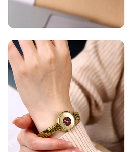 Close-up of elegant gold watch with vintage red dial and metallic elastic strap detail