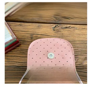 Dettaglio borsa a tracolla rosa con cuori intagliati al laser e chiusura magnetica