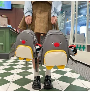 Comparaison détaillée de deux sacs à dos pingouin mignons de tailles différentes avec peluche