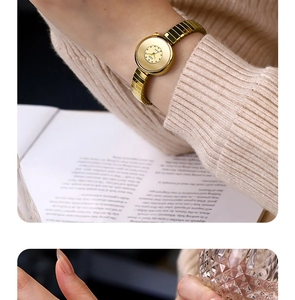 Detail shot of elegant gold quartz watch with elastic metal band on warm knitwear
