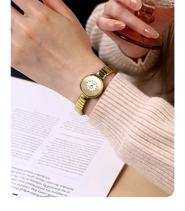 Close-up of GEDI gold quartz watch with minimalist dial and elastic metal band on wrist