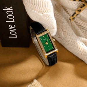 Vintage rectangular gold watch with green dial and black leather strap on soft knit fabric